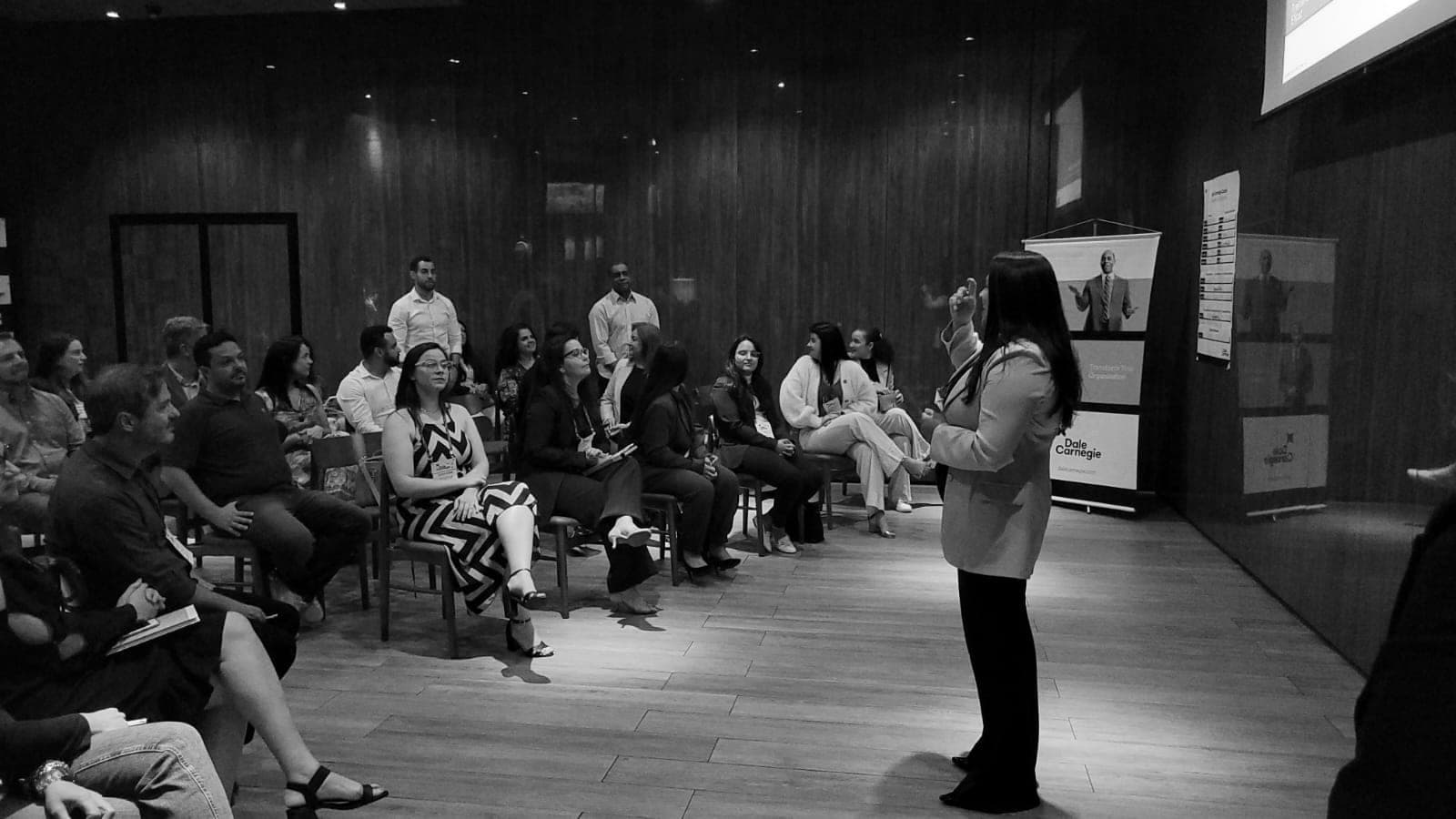 Facilitadora conduzindo dinâmica com a turma reunida em roda