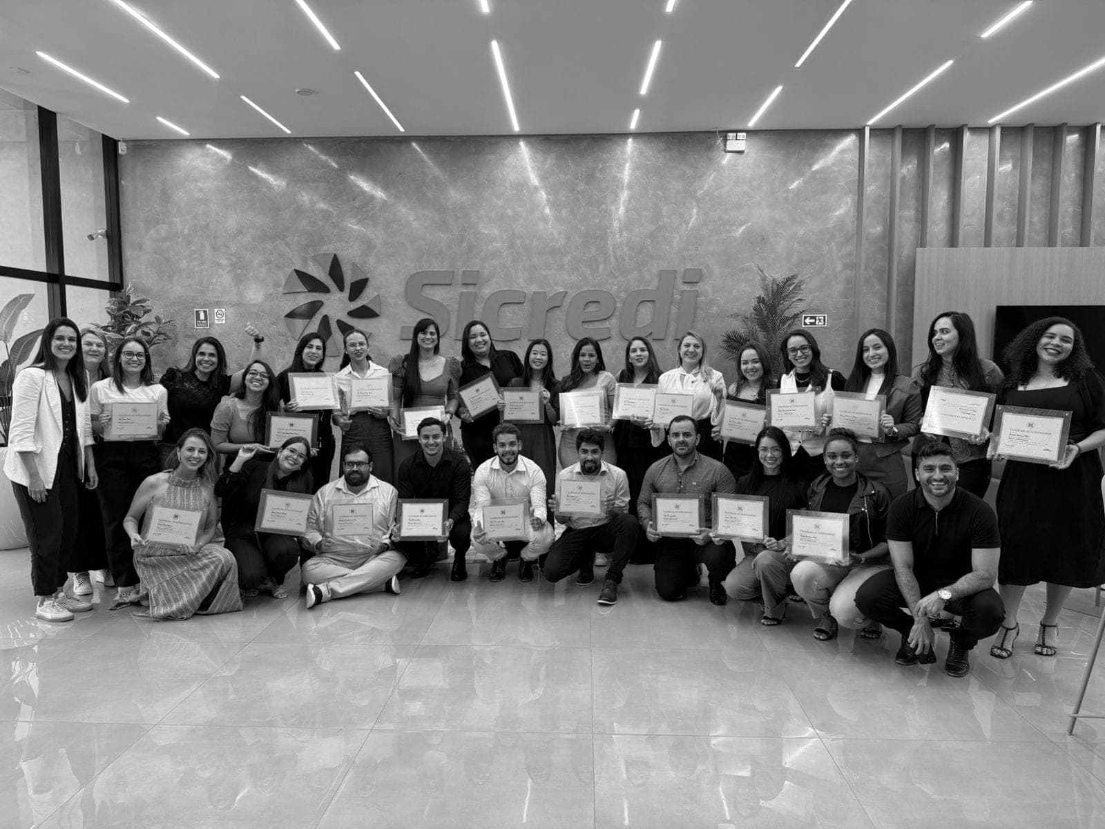 Equipe da Sicredi reunida com certificados após treinamento Dale Carnegie